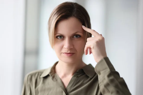 Portrait of a thoughtful woman with a finger on the forehead, close-up. Business woman, brainstorming