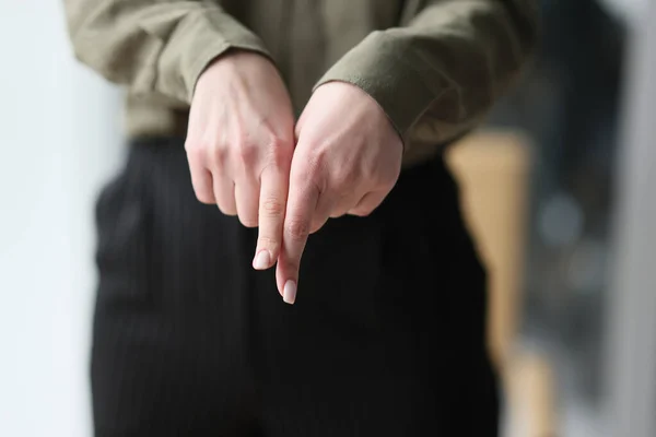 A woman shows with different hands with index fingers down, a close-up. Confrontation concept at work