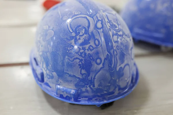 Close-up of dusty blue protective building helmet on table. Safety in construction. Protective building equipments