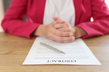 Close-up woman sitting at table in office, signing contract agreement. Signing and concluding business contracts