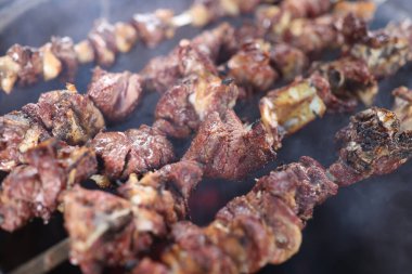 Izgara sulu et ve dumanlı birkaç şişe yakın çekim. Barbeküyü ateşte pişirmek.