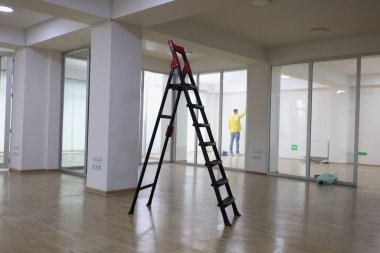Yüksek merdiven boş ofisin ortasında duruyor. Yeni ticari gayrimenkul, ofis yenileme ve geliştirme konsepti kirala.