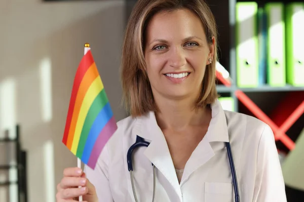 Doctora Sonriente Sostiene Bandera Del Arco Iris Lgbt Mano Clínica — Foto de Stock