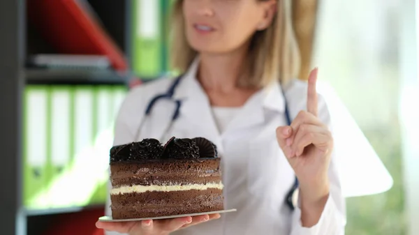 Dietologen Håller Chokladkakan Händerna Och Visar Upp Pekfingret Läkaren Rekommenderar — Stockfoto