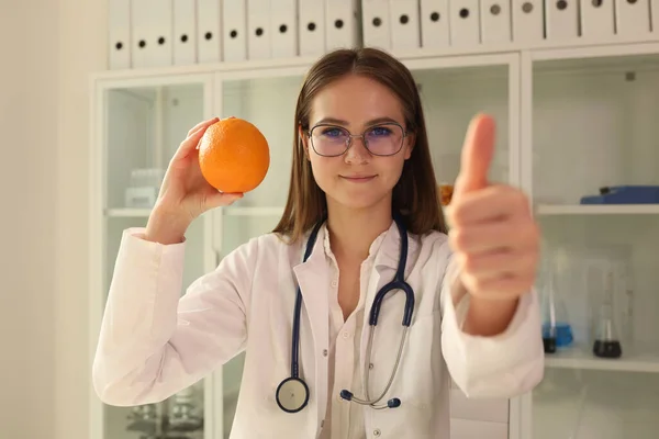 Ung Dietist Håller Apelsinfrukt Och Visar Tummen Upp Dietolog Råder — Stockfoto