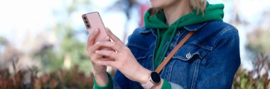 Portrait of woman looking at smartphone screen and smiling. Happy woman messaging using cellphone or having video call with friends