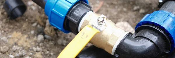 Close-up of elbow fitting, pvc pipes at bend with faucet. Underground irrigation system. Plumbing water drainage installation
