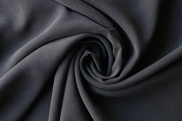 用棉布制成的卷曲深灰色面料 在纺织品商店缝制材料样品 在客厅里做衣服用的软布 — 图库照片