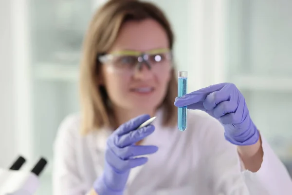 Kobieta Gumowych Rękawiczkach Posiada Szkło Niebieskim Płynem Chemicznym Badań Naukowych — Zdjęcie stockowe