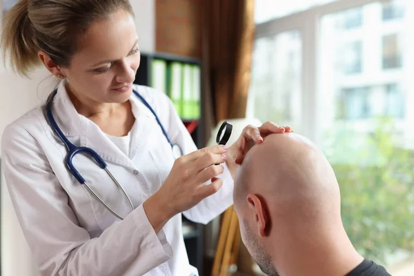 Kvinnlig Läkare Med Förstoringsglas Kontrollerar Patientens Huvud Hud Kliniken Kontor — Stockfoto