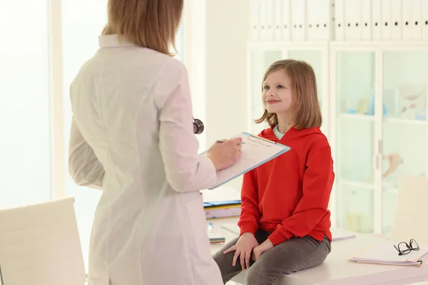 クリップボードを持った医師は入院中に少女を診察する 小児科医インタビュー患者 子供のための近代的な医療 — ストック写真