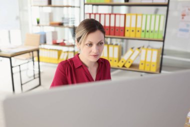 Konsantre kadın şirket ofisindeki bilgisayarda çalışıyor. Şirket çalışanı iş yerinde iş yapar. Profesyonel menajer kariyeri