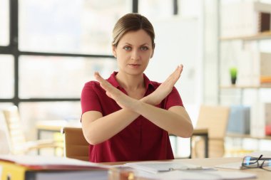 Kadın yönetici şirket ofisindeki masa başında Stop hareketini gösteriyor. Sarışın uzman müşteri talebini reddediyor. Hizmet reddetme performansı