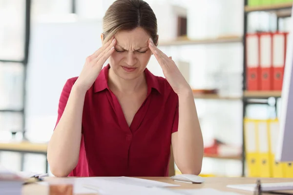 職場の閉鎖で片頭痛の強い女性のオフィスワーカー 従業員は職場での緊張感を強調した 過労による頭痛の問題 — ストック写真