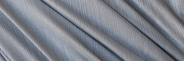 Closeup of gray synthetic fabric with folds. Abstract fabric background