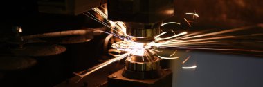 Metal kesme işlemine yakın çekim ve neon kıvılcımlar uçuşuyor. Lazer kesme makinesi ve metal levha. Üretim ve üretim kavramı