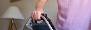 Close-up of woman ironing bed linen on special board. Woman doing housework. Housekeeping and household chores concept