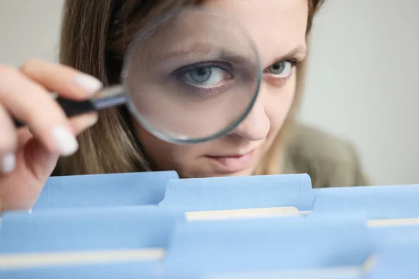Женщина Смотрит Сквозь Лупу Голубых Папках Файлами Помещенными Ряд Секретарь — стоковое фото