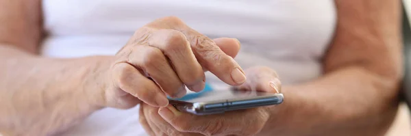 現代的なスマートフォンを手に持つ老婦人のクローズアップ おばあちゃんが携帯電話で 親戚とのコミュニケーション 老齢と感性の概念 — ストック写真