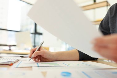 Müdür, istatistiklerle kurgu yaparak ve verileri karşılaştırarak soruşturma kağıtlarını okuyor. Masada özenli bir kadın yazı işleri yapıyor.