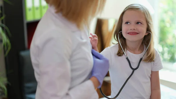 Menina Curiosa Verifica Batimento Cardíaco Mulher Com Estetoscópio Sorrindo Criança — Fotografia de Stock