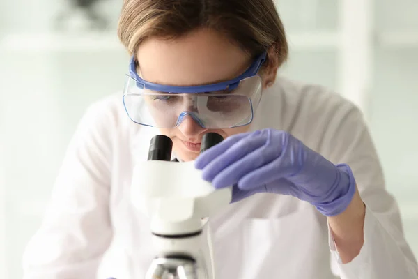 Mujer Científica Concentrada Gafas Protectoras Examina Muestra Con Microscopio Electrónico — Foto de Stock