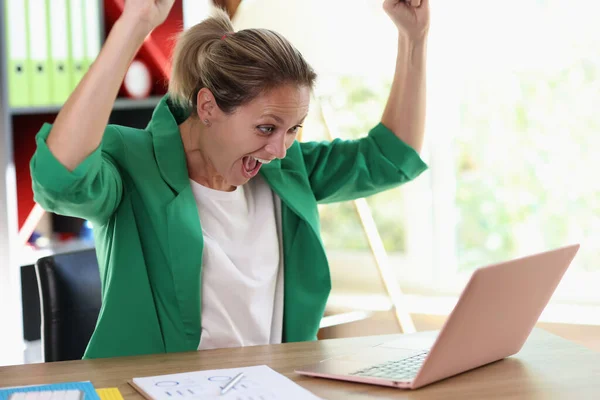 幸せな女性は喜びを感じるウェブサイトのプロジェクトの評価を点検する 感情的な女性マネージャーは手を上げ オフィスでラップトップの画面を見て悲鳴 — ストック写真