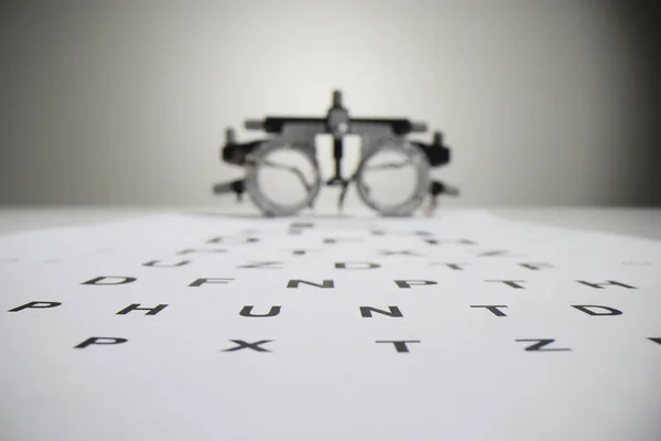 Üzerinde Snellen Çizelgesi Olan Beyaz Kağıt Bulanık Göz Farı Gözlüklerine — Stok fotoğraf
