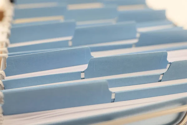 Close-up of folders with documents and project papers putted in order. Archive and old materials saved in file cabinet in office. Paperwork concept