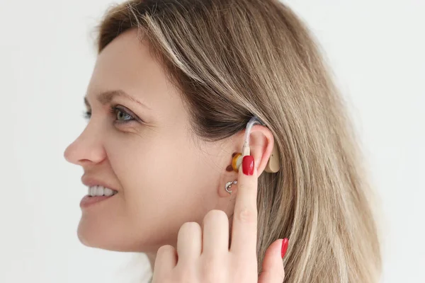 Happy Woman Shows Using Contemporary Hearing Aid Studio Digital Device — Stock Photo, Image