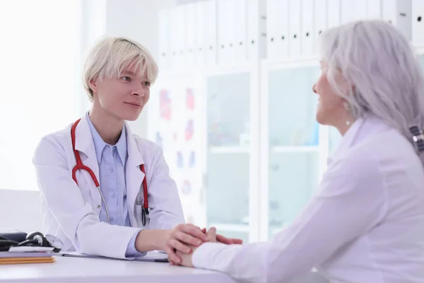 Pozytywny Lekarz Trzyma Dojrzałą Kobietę Ręce Podczas Konsultacji Gabinecie Szpitalnym — Zdjęcie stockowe