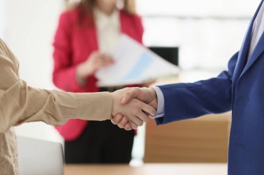 Şirket ofisindeki kârlı anlaşmadan sonra iş ortakları el sıkışıyor. Kadın ve erkek konferans salonunda el sıkışarak selamlaşırlar. Başarılı bir anlaşma