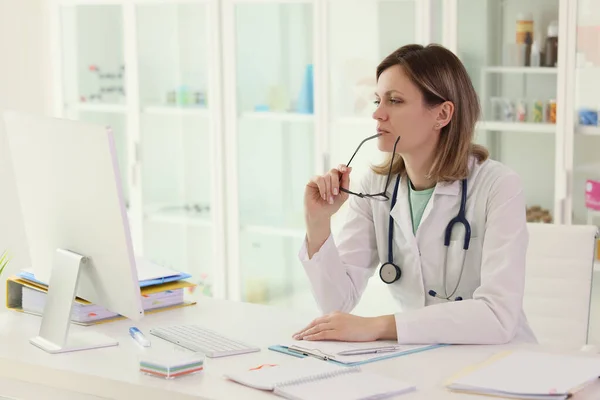 Mujer Médico Sosteniendo Gafas Examina Cuidadosamente Los Datos Computadora Médico — Foto de Stock