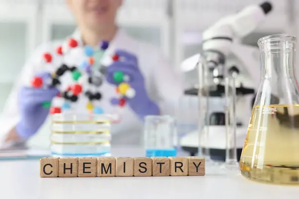 Słowo Chemia Wykonana Drewnianych Kostek Pobliżu Laboratoryjnego Szkła Żółtym Płynem — Zdjęcie stockowe