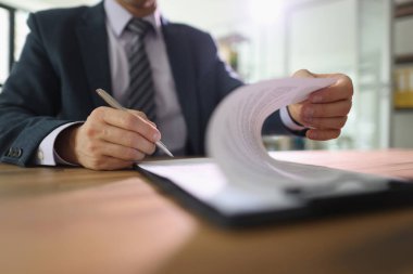İşadamı, masada otururken kontratı imzalıyor. Şirket CEO 'su masadaki pazarlıktan sonra ticari anlaşmayı onayladı