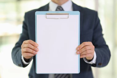 Çalışan şirket ofisindeki panoda boş kağıt kağıtları gösteriyor. Yönetici tasarım için boş belgeyi tutuyor. Reklam pankartı