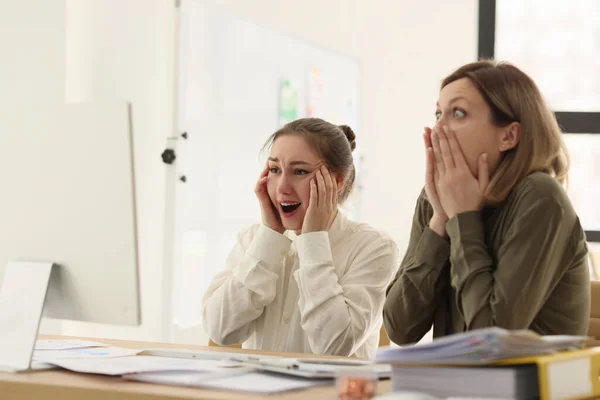 ショックを受けた女性管理者は デスクでコンピュータモニタを見ています オフィスのオンライン情報に感銘を受けた同僚 転落率で怖がる女性 — ストック写真
