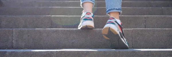 Κοντινό Πλάνο Γυναικείων Ποδιών Τζιν Και Αθλητικά Ανεβαίνουν Απότομες Σκάλες — Φωτογραφία Αρχείου