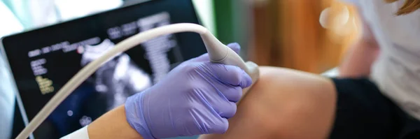 stock image Close-up of specialist making ultrasound diagnostics of knee joint of little child. Doctor diagnosing injuries or defects of kid. Medicine and healthcare concept