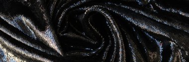 Top view of black cloth with shiny coating abstract background. Stylish wavy fabric texture backdrop
