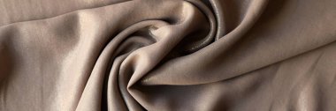 To view of sample crumpled beige fabric with shiny coating for catalogue. Pattern of cloth for design and art work or sewing