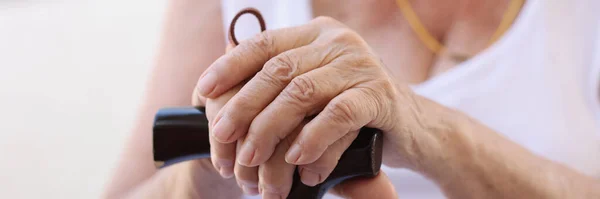 高齢者の年金受給者木製の杖を閉じて手を握っている 疲れ成熟した年金受給者休息後に痛みを伴う歩くとともにアスティック — ストック写真