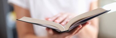 Kitapçıda açık kağıt kitap okuyan kadın çok satan kitap konsepti. Okumak ve eğlenmek hobi modern edebiyat evde yakın çekim