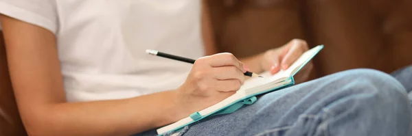 Close Mulher Sentada Sofá Escrevendo Algo Bloco Notas Tomando Notas — Fotografia de Stock