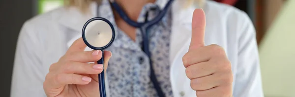 女医生在诊所的特写镜头 展示听诊器和拇指向上的标志 医药和保健概念 — 图库照片