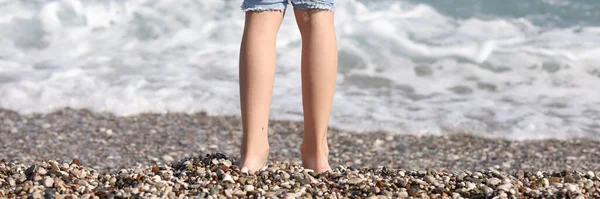 閉じる小石のビーチで海に立って小さな子供のアップ 絵のように美しい海岸 夏休み ビーチホリデーのコンセプト — ストック写真