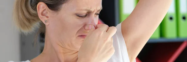 不幸な女が脇の下の匂いがする 脇の下の不快な匂いと健康問題の概念 — ストック写真