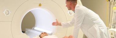 Doctor examining female patient with CT scanner in hospital. Woman visiting MRI procedure in medical clinic.