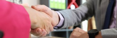 Close-up of two business people shaking hands at office table. Successful partnership, completed deal and agreement concept.