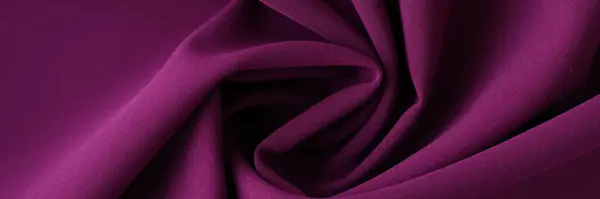 Shaped purple fabric as background or design element. Waved purple textile closeup.